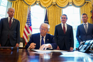 U.S. President Donald Trump signs an executive order in the Oval Office at the White House in Washington, D.C.