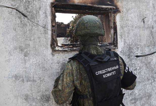 RUSSIA, KHERSON REGION - JULY 14, 2023: An employee of the Russian Investigative Committee visits a house burned down af